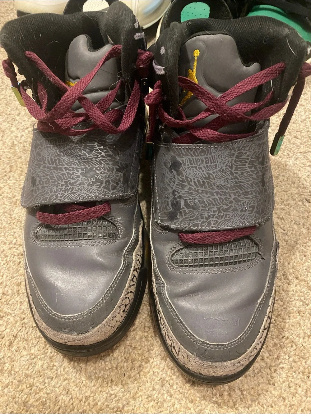 Jordan 2012’s Burgundy and Gray High-Top Sneakers with yellow and teal Accents.